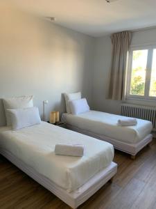 two beds sitting next to each other in a bedroom at Hôtel Le Costellan in Dagneux