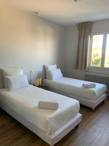 Duas camas sentadas uma ao lado da outra num quarto em Hôtel Le Costellan em Dagneux