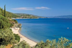 a beach with people swimming in a large body of water at Katia Hotel in Afissos