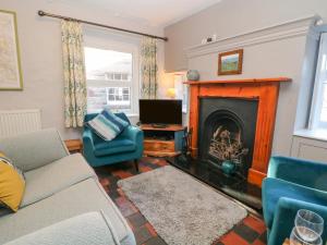 a living room with a couch and a fireplace at East Bank Cottage in Matlock