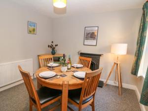 - une salle à manger avec une table et des chaises en bois dans l'établissement East Bank Cottage, à Matlock