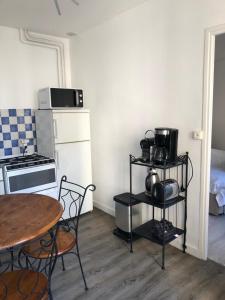 a small kitchen with a table and a table and chairs at Champoiseau in Tours