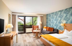 マイカンマーにあるHotel-Residenz Immenhofのベッドとソファ付きのホテルルーム