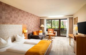 una camera d'albergo con letto e soggiorno di Hotel-Residenz Immenhof a Maikammer