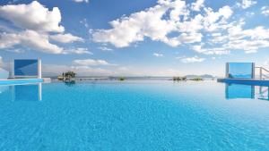 ein großer Pool mit blauem Wasser mit wolkigem Himmel in der Unterkunft Hotel C Resort in Yeosu