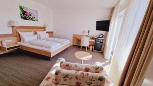 um quarto de hotel com uma cama e um sofá em Hotel Garni em Metzingen
