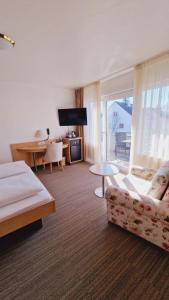 um quarto de hotel com uma cama, um sofá e uma mesa em Hotel Garni em Metzingen