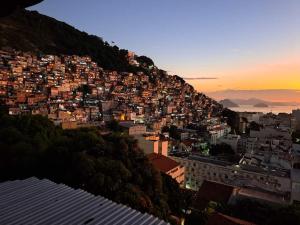 a city on top of a hill at sunset at Pousada Favela Cantagalo in Rio de Janeiro