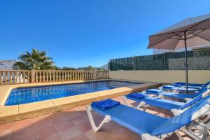 a swimming pool with lounge chairs and an umbrella at Monte Amarillo in Jávea