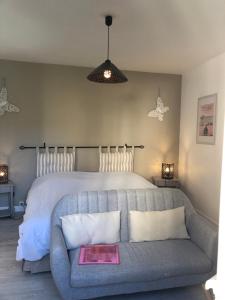 a bedroom with a bed and a couch with a book at Champoiseau in Tours