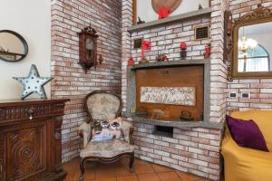 a room with a brick wall with a chair and a fireplace at Casa Stella Malpensa in Cassano Magnago