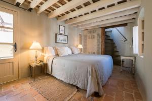 a bedroom with a bed in a room with a staircase at Hotel La Casa del Califa in Vejer de la Frontera