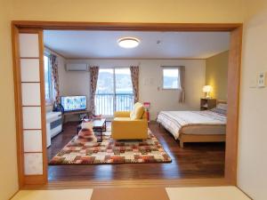 a bedroom with a bed and a cat sitting in a chair at Opopo home 竜宮店 in Otaru