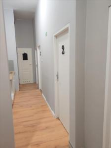 un pasillo con paredes blancas y suelo de madera en Rynek 7, en Poznan