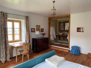 a bedroom with a blue couch and a mirror at Temelhof - Landhaus mit Sauna und Kamin in Sittersdorf