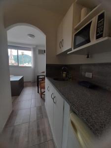 a kitchen with white cabinets and a counter top at Departamento temporario en Salta la Linda in Salta