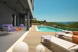 a house with a swimming pool with chairs and a swimming pool at Seaview Villa Flora - Heated pool and Spa in Omiš