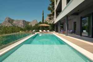 ein Schwimmbad neben einem Haus mit einem Berg in der Unterkunft Seaview Villa Flora - Heated pool and Spa in Omiš