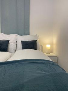 a bedroom with a large bed with a blue blanket at Lux Apartment near Frankfurt! in Mörfelden-Walldorf