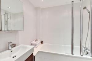 een witte badkamer met een wastafel en een douche bij Chiltern Street Serviced Apartments by Globe Apartments in Londen