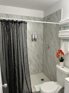 ein Bad mit einem Duschvorhang und einem WC in der Unterkunft Incredible comfortable apartments near the airport and beaches in Tampa