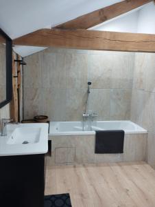 ein Badezimmer mit einer Badewanne und einem Waschbecken in der Unterkunft La Coquille in Pouillon