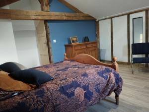 Schlafzimmer mit einem Bett mit blauer Wand in der Unterkunft La Coquille in Pouillon