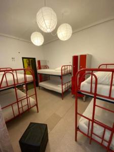マドリードにあるバルビエリ ソル オステルの二段ベッド3組と照明2つが備わるお部屋です。