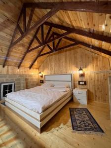 Cama grande en habitación con paredes de madera en Lakeside Garden - Ismayilli Guest house, en İsmayıllı