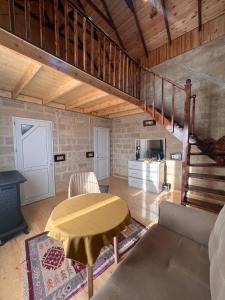 sala de estar con mesa y escalera en Lakeside Garden - Ismayilli Guest house, en İsmayıllı