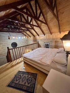a large bed in a room with a wooden ceiling at Lakeside Garden - Ismayilli Guest house in İsmayıllı