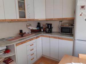 uma cozinha com armários brancos e um frigorífico branco em Savonlinnan keskusta em Savonlinna