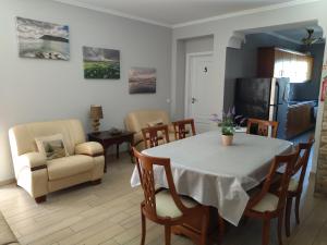 eine Küche und ein Wohnzimmer mit einem Tisch und Stühlen in der Unterkunft Hospedaria Isaias in Angra do Heroísmo