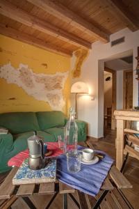 ein Wohnzimmer mit einem Tisch und einem grünen Sofa in der Unterkunft Casa Verde in Catania