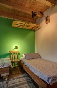 ein Schlafzimmer mit grünen Wänden, einem Bett und einem Stuhl in der Unterkunft Casa Verde in Catania