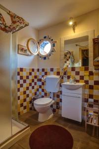 ein Badezimmer mit einem WC, einem Waschbecken und einem Spiegel in der Unterkunft Casa Verde in Catania