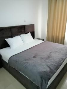 a bedroom with a large bed with white pillows at Nuben Court-Accra in Accra