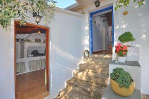eine Treppe, die zu einem Haus mit einer Tür und Pflanzen führt in der Unterkunft Skopelos Mortero Cottage in Panormos Skopelos