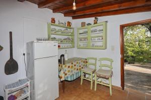 eine Küche mit einem Kühlschrank sowie einem Tisch und Stühlen in der Unterkunft Skopelos Mortero Cottage in Panormos Skopelos