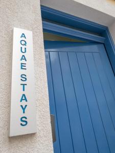 a blue garage door with a sign on it at Aquae Stays in St Paul's Bay
