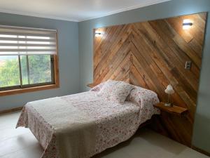 Los Rábanos的住宿－Viejoboldo_latrinchera，一间卧室设有一张床和木墙