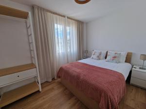 um quarto com uma cama com um cobertor vermelho e uma janela em Funchal Downtown Flats 2 no Funchal