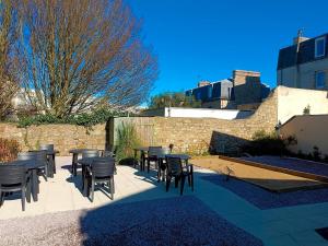 - un ensemble de tables et de chaises sur une terrasse dans l'établissement Hôtel de la Mairie, à Saint-Pol-de-Léon