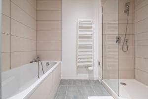 ランスにあるIKIZEN - Royal Confort - Cathédrale - Hypercentre - Parkingの浴槽とシャワー付きの白いバスルーム +25枚の写真