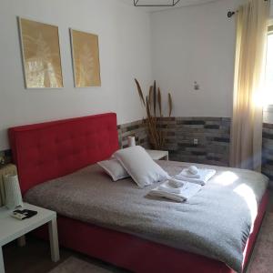 a bedroom with a bed with a red head board at PremiumGuestKifissia in Athens