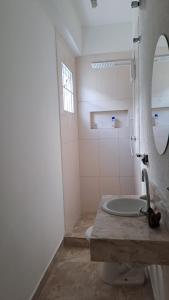 een badkamer met een wastafel, een toilet en een spiegel bij CASA AZUL in Peruíbe