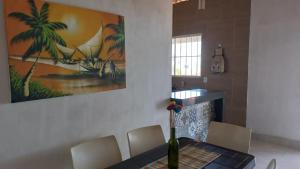 a dining room with a table and a painting on the wall at Recanto do Sossego Tavares in Baía da Traição