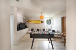a living room with a table and a surfboard on it at Little Cottage in Praa Sands