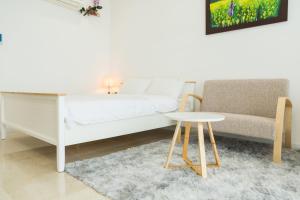 een slaapkamer met een bed, een tafel en een bank bij Vinhomes D’capitale studio in Hanoi