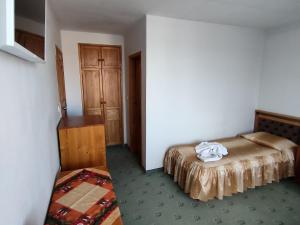 ein Schlafzimmer mit einem Bett und einer Kommode in einem Zimmer in der Unterkunft Guest Rooms Grachenovi in Bansko